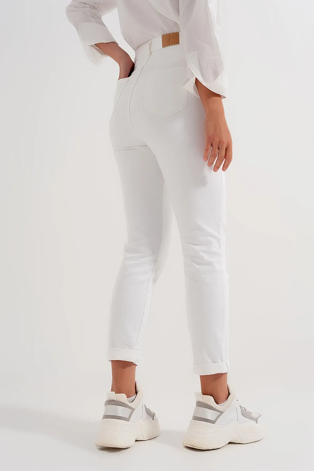 Slim jeans with asymmetric button in cream