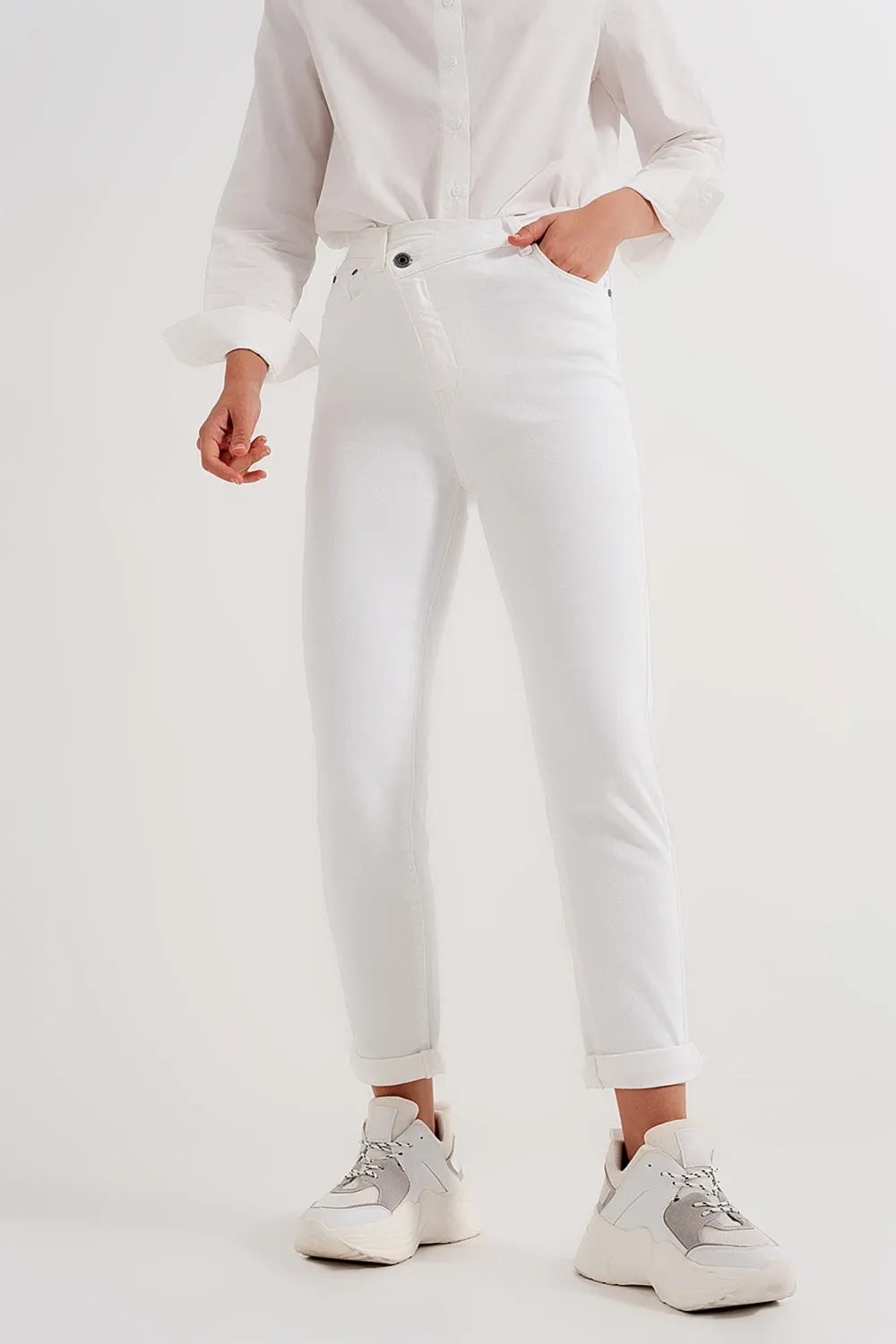 Slim jeans with asymmetric button in cream